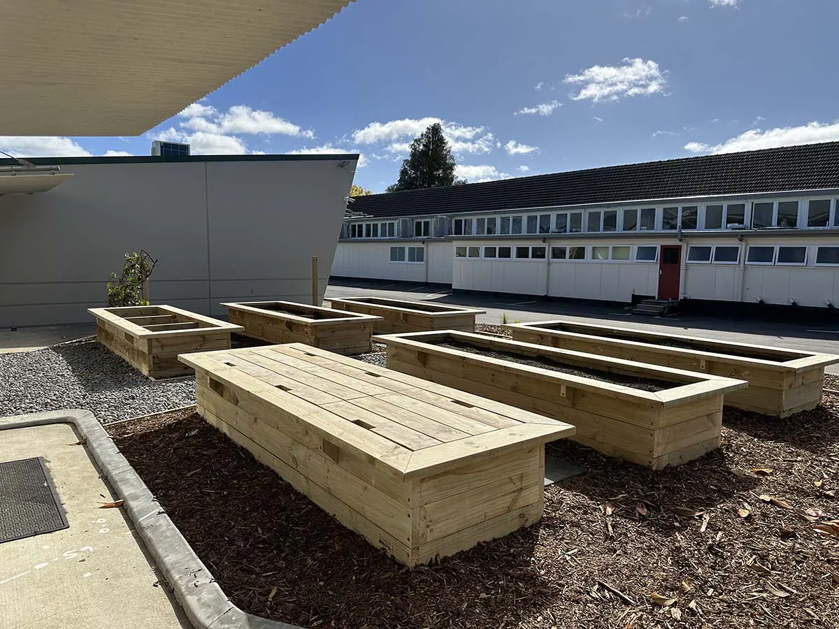 Terraced patio with modern seating and trimmed hedges.