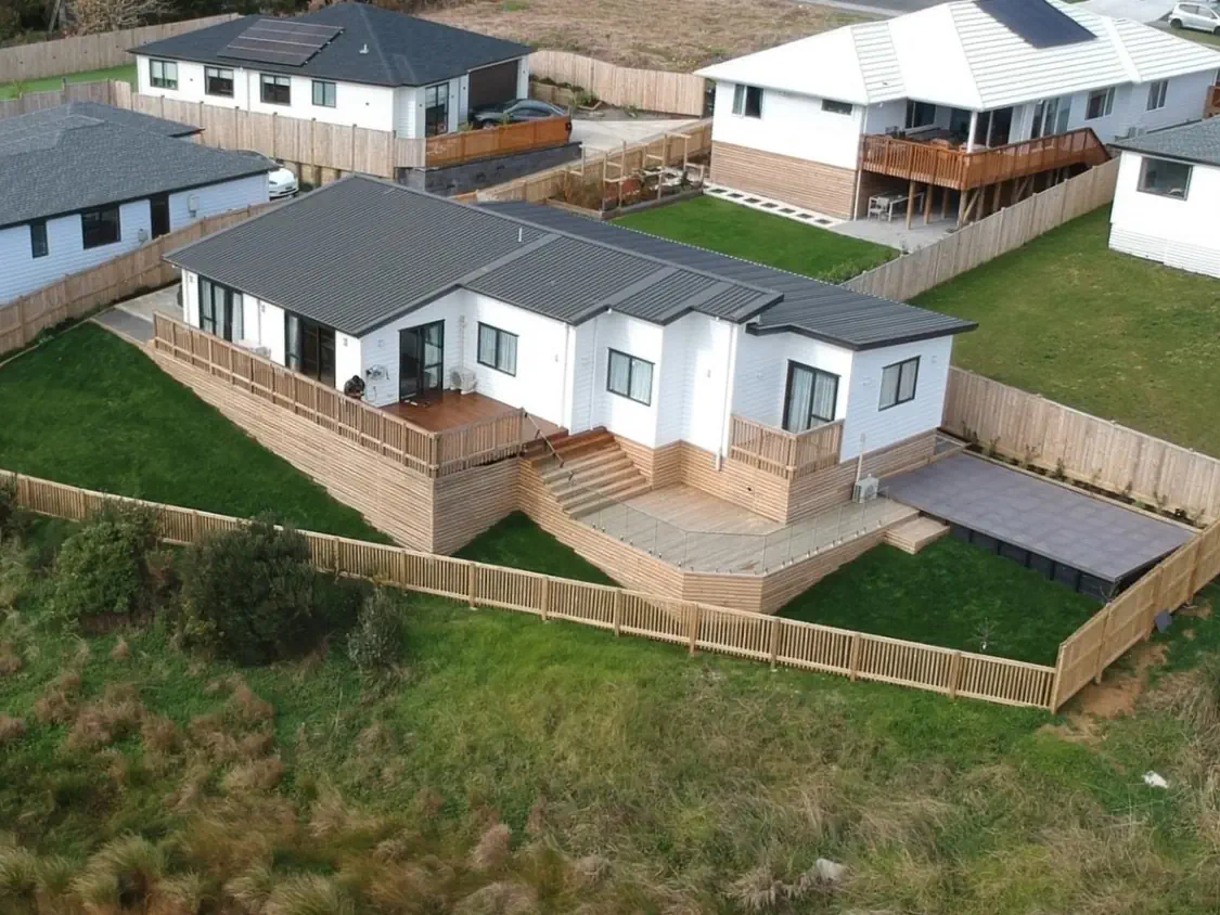 Outdoor lounge with a central fire pit and surrounding chairs.